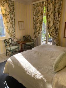 a bedroom with a bed and chairs and a window at Ristorante Stazione da Agnese & Adriana in Intragna