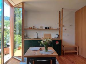 a kitchen with a table with a vase of flowers on it at Apartma Hiša 6 in Bohinj