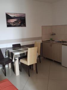 a kitchen with a table and chairs in a room at Apartments Petricevic in Sutomore