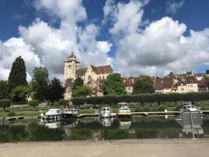 a group of boats docked in a river in front of a castle at Appartement près de DOLE in Menotey