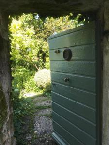 a green door in the side of a garden at Appartement près de DOLE in Menotey