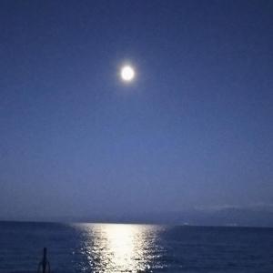 Ein Mond, der nachts über dem Ozean aufgeht in der Unterkunft Golden Sunset Beach Apartment in Skala Kallirachis