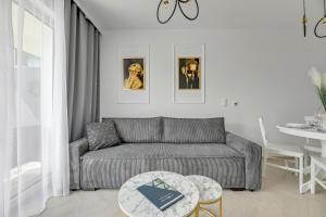 a living room with a couch and a table at Apartamenty PIAMOLA Bursztynowe Osiedle Jantar in Jantar