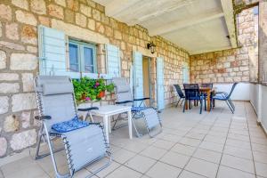 a patio with chairs and a table and a table and chairs at Kazanegra Exclusive Apartments in Sveti Stefan