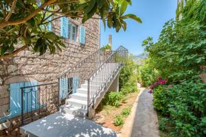 a staircase leading up to a building with flowers at Kazanegra Exclusive Apartments in Sveti Stefan