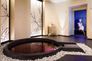 
a man standing in front of a bath tub in a room at Baglioni Hotel Regina - The Leading Hotels of the World in Rome

