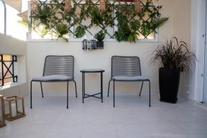 dwa krzesła i stół w pokoju z roślinami w obiekcie Luxury Premium Suite #5 w Chalkidzie