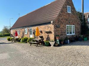 un edificio in mattoni con tavolo e ombrello giallo di Yarm cottages sleeping 12 a Kirk Leavington