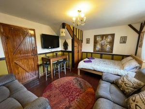 uma sala de estar com um sofá, uma cama e uma secretária em Yarm cottages sleeping 12 em Kirk Leavington