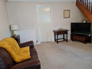 a living room with a couch and a television at Immaculate 3-Bed House with free parking in Bolton in Bolton