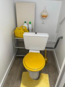 uma casa de banho com um WC com uma tampa amarela em Le cocon jaune - Studio en hyper centre em Lamballe
