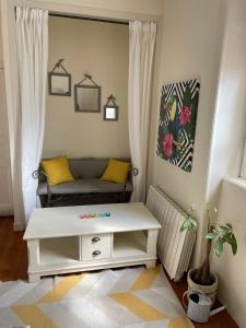 a living room with a couch and a table at Le cocon jaune - Studio en hyper centre in Lamballe
