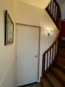 a hallway with a white door and stairs at Le cocon jaune - Studio en hyper centre in Lamballe