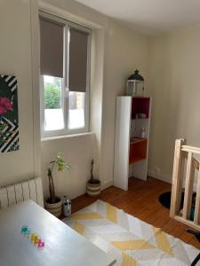 a kitchen with a white refrigerator and a table at Le cocon jaune - Studio en hyper centre in Lamballe