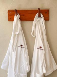 duas toalhas brancas penduradas numa parede em Uba Village em Icaraí