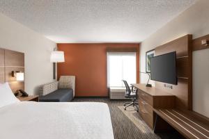 a hotel room with a bed and a flat screen tv at Holiday Inn Express Vero Beach-West I-95, an IHG Hotel in Vero Beach