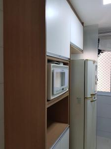 una cocina con microondas y nevera en Jockey Family Chamonix 3, en Vila Velha