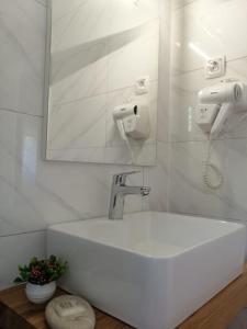 un lavandino bianco in un bagno con specchio di Plitvice Story a Laghi di Plitvice