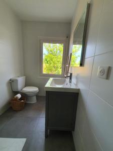 a bathroom with a sink and a toilet and a window at La Casita in Arès
