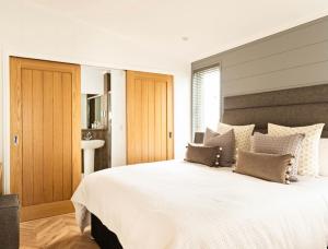 Un dormitorio con una gran cama blanca con almohadas. en Cairn Lodge, en Woodhall Spa