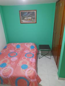 Un dormitorio con una cama rosa y una foto en la pared en Mi hospedaje, en Bogotá