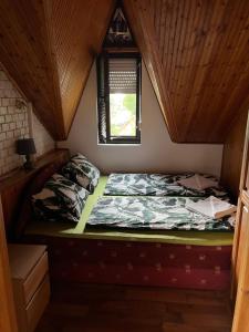 een bed in een kamer met een houten plafond bij Marika Apartman in Szántód