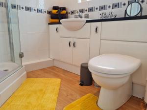 a bathroom with a toilet and a sink and a tub at Immaculate 3-Bed House with free parking in Bolton in Bolton