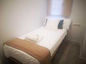 a bed with white sheets and pillows in a room at Beautiful Apartment in the heart of seville in Seville
