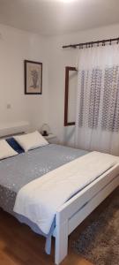 - une chambre avec un lit blanc et un rideau dans l'établissement Cilijin dvor, à Čižići