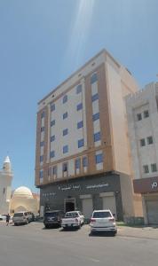 a building with cars parked in a parking lot at فندق ربوة الصفوة 8 - Rabwah Al Safwa Hotel 8 in Al Madinah