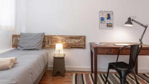 a bedroom with a bed and a desk with a lamp at RUN Aveiro in Aveiro +3 photos