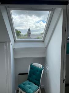 a skylight in a room with a chair and a window at Le cocon jaune - Studio en hyper centre in Lamballe