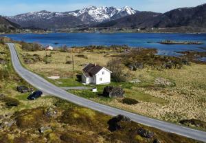 a small white house on the side of a road at Storhella - Feriehus med fantastisk beliggenhet in Sennesvik