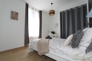 a white bedroom with a bed and a large window at Le Zen by EasyEscale in Romilly-sur-Seine