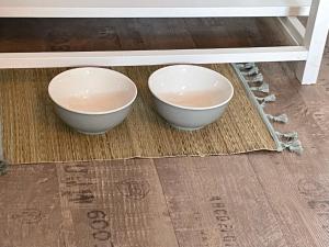 two bowls sitting on a rug under a table at Le cocon jaune - Studio en hyper centre in Lamballe