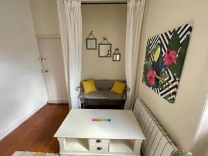 a living room with a couch and a table at Le cocon jaune - Studio en hyper centre in Lamballe
