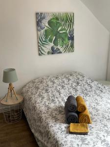 a bedroom with a bed with towels on it at Le cocon jaune - Studio en hyper centre in Lamballe