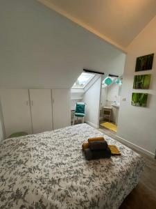 a bedroom with a bed and a chair in it at Le cocon jaune - Studio en hyper centre in Lamballe