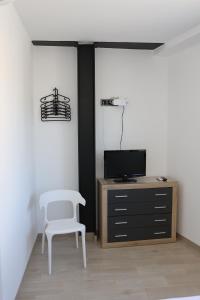 a room with a chair and a tv and a cabinet at Ca ma mare in Useras