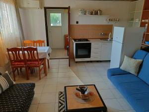 a living room with a blue couch and a kitchen at Apartments Luka in Tisno +53 photos