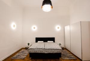 a bedroom with a bed and a white wall at Chain Bridge City Center Dorothea in Budapest