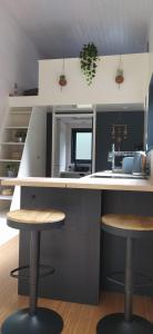 a kitchen with a counter and two stools in it at Tiny house chez Caroline in Gaillan-en-Médoc