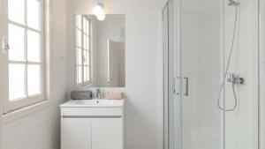 a white bathroom with a sink and a shower at RUN Aveiro in Aveiro