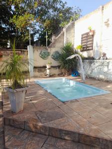 a small swimming pool with a water fountain at Hostel Néli in Aparecida