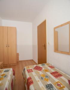 a bedroom with a bed and a mirror on the wall at Apartments Waterfront IVAN 2 in Podgora