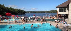 a large group of people in a swimming pool at Oak circle chalet Pocono gated community - 1 min walk to Deerfield lake in Lake Ariel