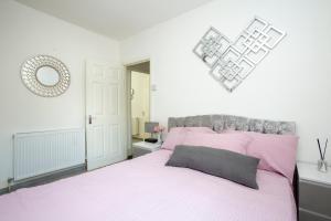 sypialnia z różowym łóżkiem i lustrem w obiekcie Dream Home Estate w Londynie