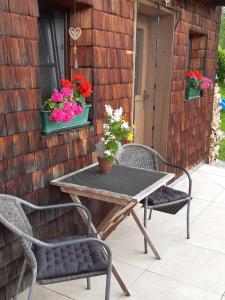 een tafel en 2 stoelen en bloemen op een patio bij Hüttenzauber in Taxenbach