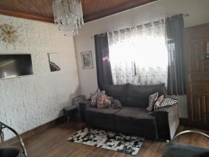 uma sala de estar com um sofá e uma janela em Hostel Néli em Aparecida