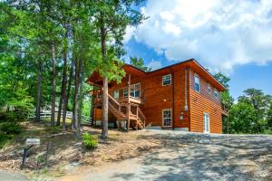 ein großes Holzhaus mit einem Baum in der Unterkunft Pine Cove Cabin - Hot Tub, Game Room, Theater Room in Pigeon Forge